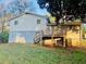 Backyard view of a house with a deck, light gray brick and a large green lawn at 120 Mossy Brook Dr, Stockbridge, GA 30281