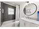 Modern bathroom featuring subway tile, a marble countertop, and a sleek, round mirror at 1558 Grant Ne Dr, Atlanta, GA 30319