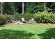 Green backyard featuring mature trees and comfortable seating around a fire pit at 2231 Fairoaks Rd, Decatur, GA 30033