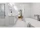 Elegant bathroom featuring dual sinks, white cabinets, soaking tub, and a separate bedroom entrance at 2231 Fairoaks Rd, Decatur, GA 30033