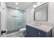 Bathroom with a glass-enclosed shower, blue vanity, and patterned tile flooring at 2231 Fairoaks Rd, Decatur, GA 30033