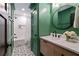 Charming bathroom with green walls, patterned tile floor, round mirror, and tub with shower at 2231 Fairoaks Rd, Decatur, GA 30033