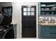 Laundry room with black door, star tile backsplash, and teal cabinets at 2231 Fairoaks Rd, Decatur, GA 30033