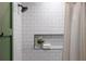 Close up of the shower with white subway tile, niche, and neutral shower curtain at 2231 Fairoaks Rd, Decatur, GA 30033