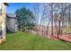 Backyard featuring a lush green lawn, mature trees, and the rear elevation of the tan sided home at 772 Crescent Cir, Canton, GA 30115