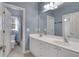 Bright bathroom featuring a double vanity, large mirror, and a shower-tub combo with stylish blue walls at 772 Crescent Cir, Canton, GA 30115