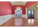 Bright living room showcasing hardwood floors, a red accent wall and decorative columns with a chandelier at 772 Crescent Cir, Canton, GA 30115