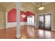 Bright living room showcasing hardwood floors, a red accent wall and decorative columns with a chandelier at 772 Crescent Cir, Canton, GA 30115