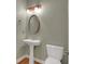 Powder room with pedestal sink, oval mirror and hardwood floor at 772 Crescent Cir, Canton, GA 30115