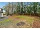 Large, open backyard with mature trees, a stone patio, and ample space for outdoor recreation and entertainment at 4072 Whispering Forest Ct, Lilburn, GA 30047