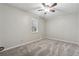 Well-lit, carpeted bedroom with a ceiling fan, window, and neutral color scheme at 4072 Whispering Forest Ct, Lilburn, GA 30047