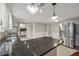 Open kitchen with stainless steel fridge, dark countertops, and lots of cabinets for storage at 4072 Whispering Forest Ct, Lilburn, GA 30047