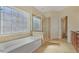 Elegant bathroom featuring a soaking tub, separate glass shower, and decorative window at 4669 Prater Se Way, Smyrna, GA 30080