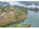 Stunning aerial view of lakefront home surrounded by verdant trees and blue waters perfect for relaxation at 5975 P W A Dr, Cumming, GA 30041