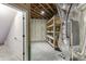 Well-lit basement utility area shows a utility unit, shelving, and ample storage with insulated walls and open ceiling at 5975 P W A Dr, Cumming, GA 30041