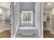 A luxurious bathroom showcasing a standalone tub with views of the outdoors at 5975 P W A Dr, Cumming, GA 30041