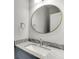 Bathroom vanity with grey granite countertop, round mirror, and chrome faucet at 5975 P W A Dr, Cumming, GA 30041