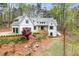 Charming two-story white home with a stone walkway and a two-car garage nestled in a lush, green landscape at 5975 P W A Dr, Cumming, GA 30041