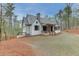 Charming home with a stone chimney, a covered porch, and a well-manicured lawn set against a backdrop of lush trees at 5975 P W A Dr, Cumming, GA 30041