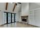 Living room featuring exposed beams, a stone fireplace with built-in shelving, and French doors at 5975 P W A Dr, Cumming, GA 30041