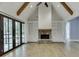 Cozy living room with a stone fireplace, built-in shelving, exposed beams, and French doors to outdoor area at 5975 P W A Dr, Cumming, GA 30041