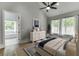 Light-filled main bedroom featuring hardwood floors, decorative dresser, and an ensuite bathroom at 5975 P W A Dr, Cumming, GA 30041