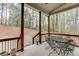 Covered patio with an outdoor dining table surrounded by peaceful wooded views at 5975 P W A Dr, Cumming, GA 30041