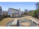 Large, fenced backyard with a covered patio, fire pit, and stone landscaping at 4525 Chelton Se Ct, Smyrna, GA 30080
