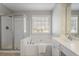 Well-lit bathroom features a shower, bathtub, sink and mirror at 4525 Chelton Se Ct, Smyrna, GA 30080