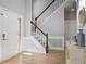 Inviting foyer features hardwood floors, a staircase with white and wood banister, and a decorative mirror at 4525 Chelton Se Ct, Smyrna, GA 30080