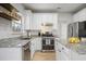 Bright kitchen features stainless appliances, granite countertops, white cabinetry, and wood floors at 4525 Chelton Se Ct, Smyrna, GA 30080