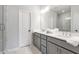 Bright bathroom featuring a double sink vanity with gray cabinets, a large mirror, white marble and glass shower at 6785 Pippin Walk, Alpharetta, GA 30005
