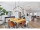 Open-concept dining area with modern chandelier and hardwood floors that flows into the kitchen at 6785 Pippin Walk, Alpharetta, GA 30005