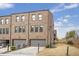 Brick townhome exterior showcasing two-car garage and manicured landscaping at 6785 Pippin Walk, Alpharetta, GA 30005