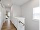Bright hallway with hardwood floors leading to a bedroom with natural light and a white dresser with a small handrail at 6785 Pippin Walk, Alpharetta, GA 30005