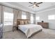 An open Primary bedroom features a tray ceiling with fan, large windows, bedside tables, and a decorative display cabinet at 6785 Pippin Walk, Alpharetta, GA 30005