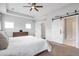 An inviting Primary bedroom features sliding barn doors, a tray ceiling and a lovely color palette at 6785 Pippin Walk, Alpharetta, GA 30005