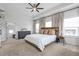 Spacious main bedroom featuring a tray ceiling with fan, large windows, bedside tables, and a decorative display cabinet at 6785 Pippin Walk, Alpharetta, GA 30005