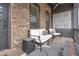 Cozy covered porch featuring comfortable seating and an outdoor fireplace at 6785 Pippin Walk, Alpharetta, GA 30005