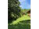 Lush backyard bordered by mature trees, with ample sunlight and a gently sloping lawn at 1902 Godby Rd, Atlanta, GA 30349