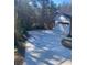 Long paved driveway leading up to a garage with a white door, surrounded by greenery at 1902 Godby Rd, Atlanta, GA 30349