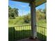Covered porch featuring a wrought iron railing and a view of overgrown shrubs at 1902 Godby Rd, Atlanta, GA 30349