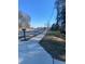 View of a sidewalk next to a road with trees and utility poles under a blue sky at 1902 Godby Rd, Atlanta, GA 30349