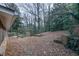 Wooded backyard with a small wooden deck and brick features at 2634 Arrowood Dr, Atlanta, GA 30344