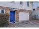 Close up of the home's entrance featuring a bright blue door, brick facade and a one car garage at 2634 Arrowood Dr, Atlanta, GA 30344