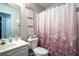 Bright bathroom with a toilet and vanity with decor, plus a shower with a patterned curtain at 555 Burnham Rdg, Lawrenceville, GA 30046