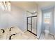 Bathroom with double vanity, marble countertop, tiled glass shower, and ample natural light at 1064 Eastview Ne Rd, Conyers, GA 30012