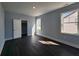 Light-filled bedroom with dark hardwood floors, pale blue walls, and two windows at 1064 Eastview Ne Rd, Conyers, GA 30012