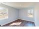 Bedroom features hardwood floors and windows with white trim at 1064 Eastview Ne Rd, Conyers, GA 30012