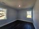 Cozy bedroom with hardwood floors, light blue walls, and two windows at 1064 Eastview Ne Rd, Conyers, GA 30012